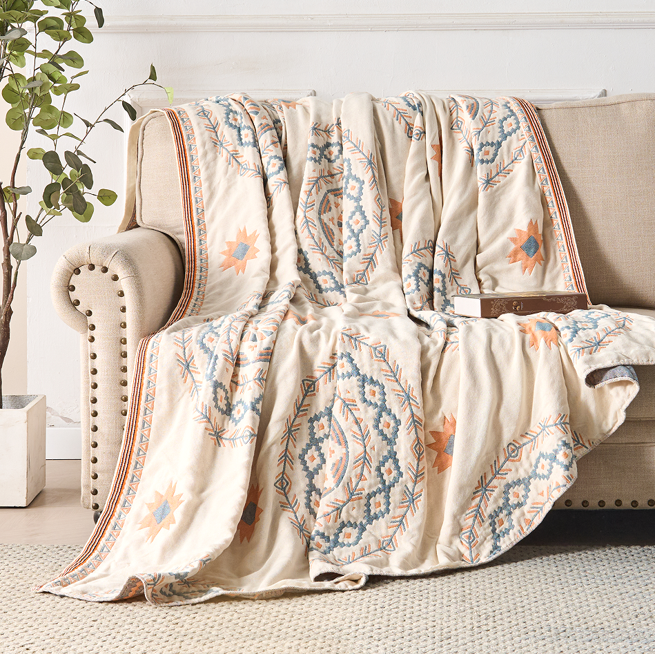 Cream boho mandala throw blanket with geometric border on sofa