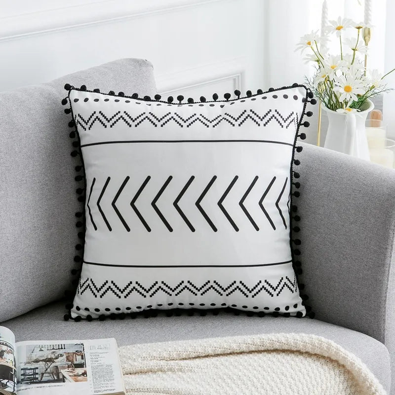 Black and white chevron pattern throw pillow with triangle bands and pom-pom trim