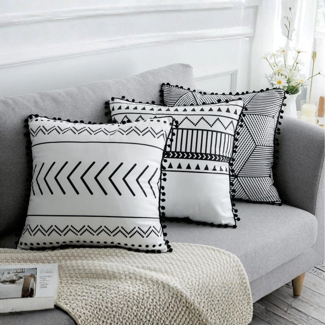 Set of five black and white geometric bohemian throw pillows with pom-poms and tassels