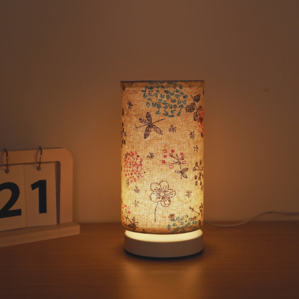 Small beige fabric table lamp with floral and insect design for desk or shelf