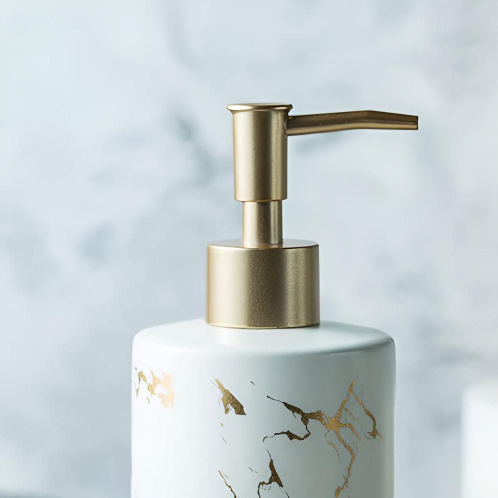 Close-up matte black ceramic soap dispenser with gold marble veining and metallic pump