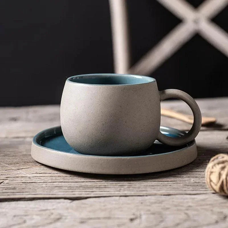 Teal glazed interior ceramic espresso cup and saucer with speckled beige exterior