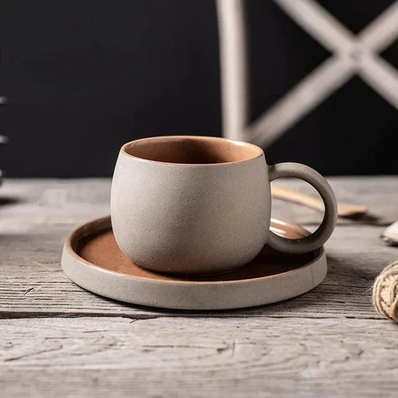 Textured sandy-beige stoneware espresso cup and saucer with warm brown interior