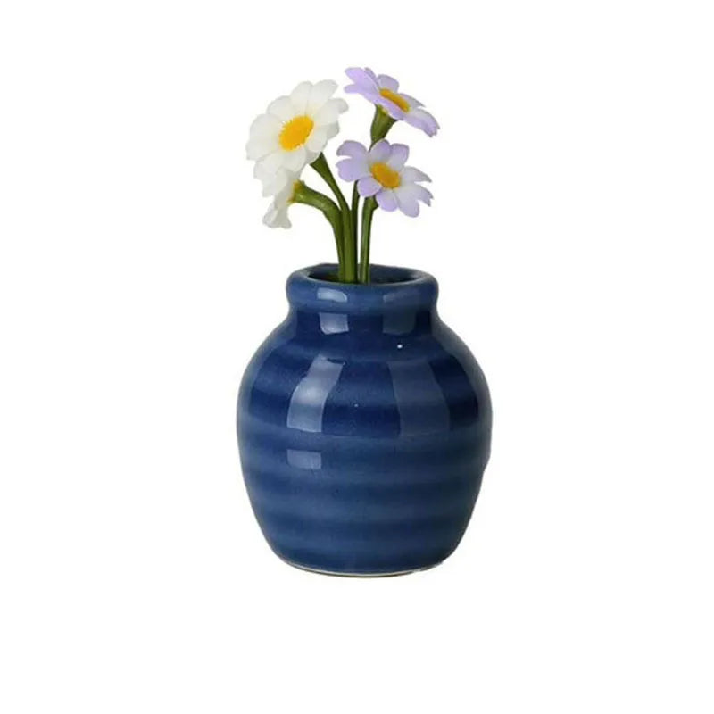 glossy blue ridged ceramic magnet vase holding white daisies