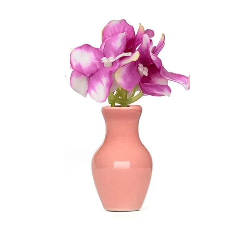 matte pink ceramic magnet vase with narrow neck and orchid-like flowers