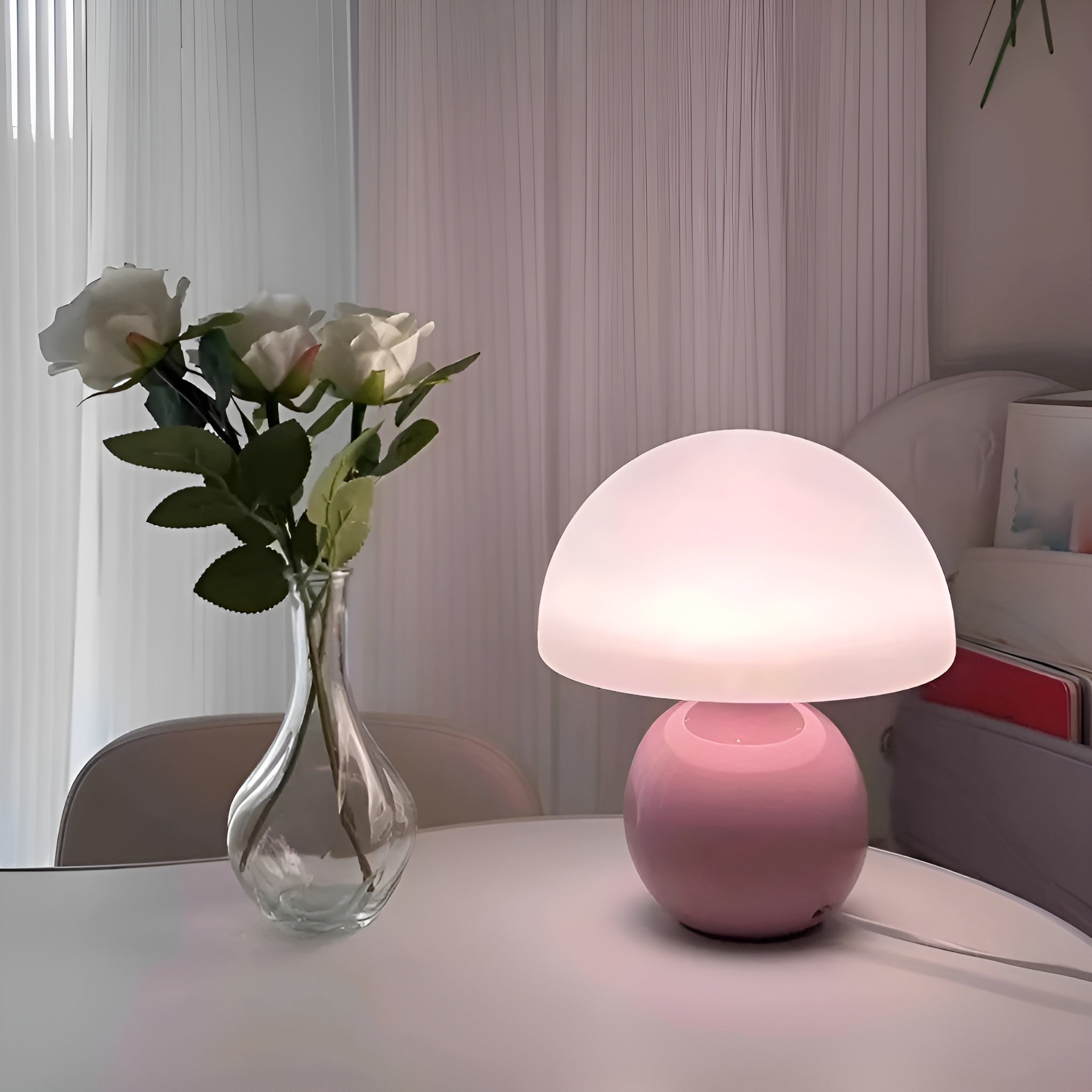 Matte pink bedside reading lamp with soft glow on white desk