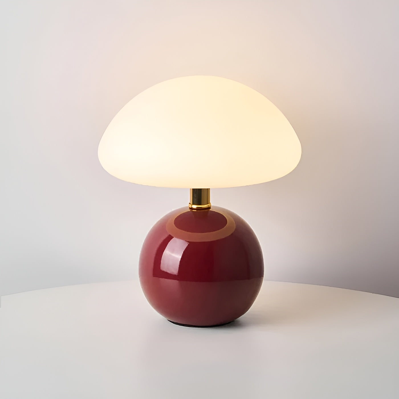 Deep burgundy round table lamp featuring gold accent collar