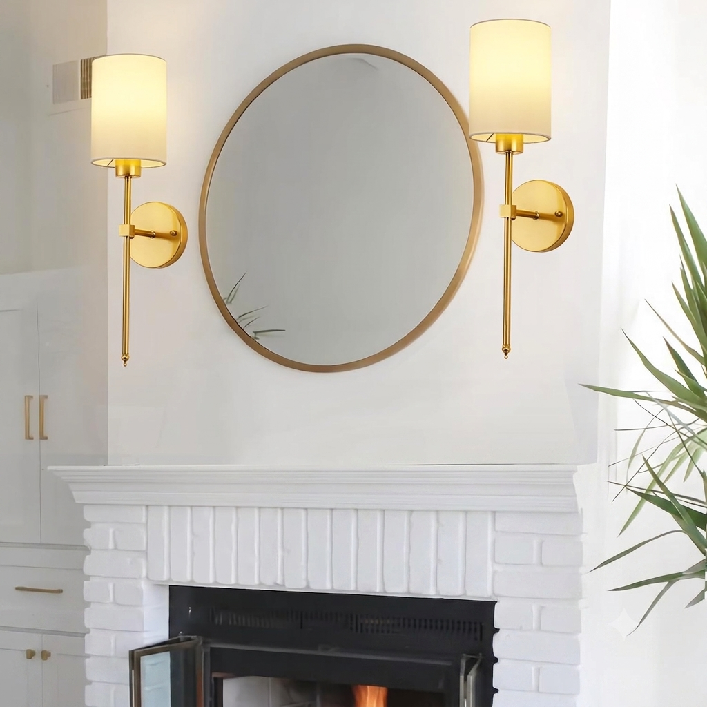Pair of gold wall lights flanking round mirror over brick fireplace