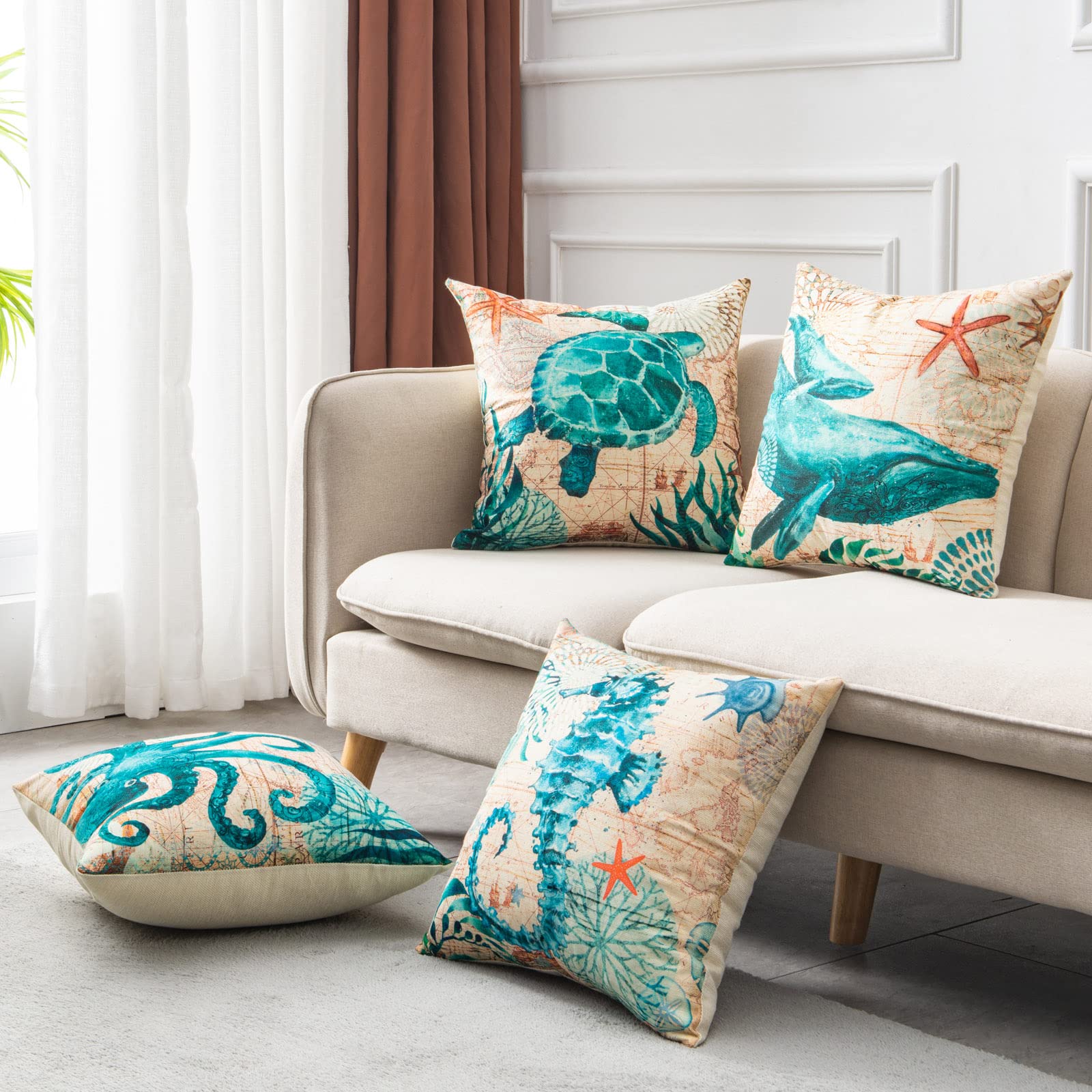 Teal sea turtle and whale pillow covers displayed on beige sofa