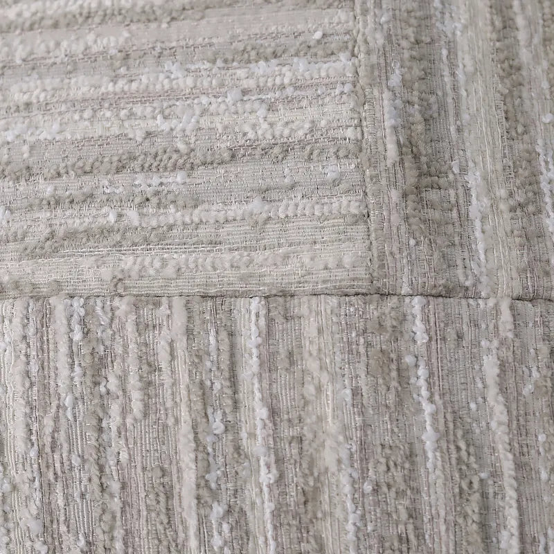 Close-up of multi-texture jacquard weave on neutral chenille and ribbed cushion cover