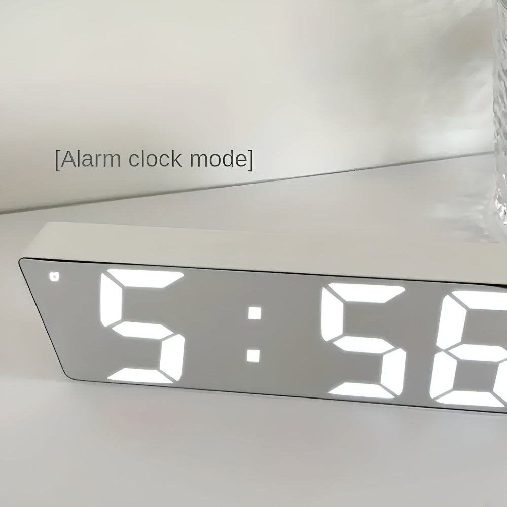 Close-up of silver framed LED mirror clock in alarm mode with indicator light