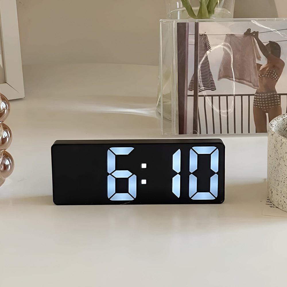 Black frame digital mirror alarm clock with large white LED display on desk