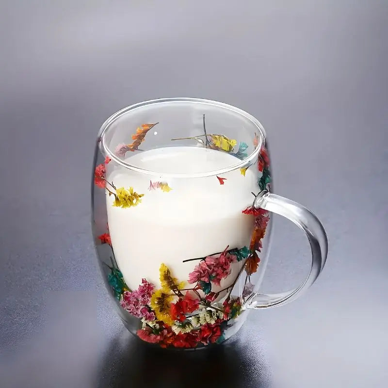 Clear double-walled coffee cup filled with milk and red pink floral suspended design