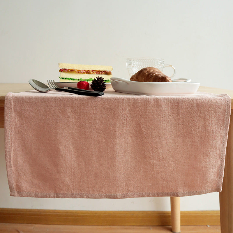 Pink cotton linen napkin draped over table edge for casual breakfast setting