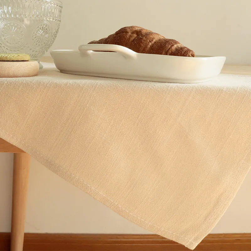 Beige cotton linen napkin draped casually on wooden table for dining
