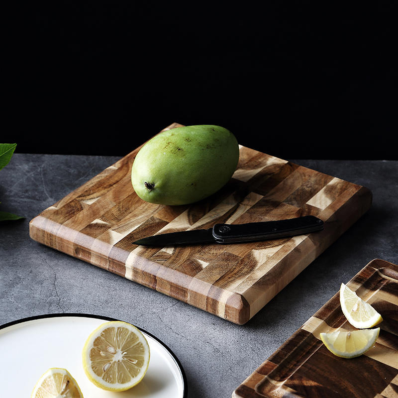 Square end grain wooden chopping board with mango, lemon, and folding knife