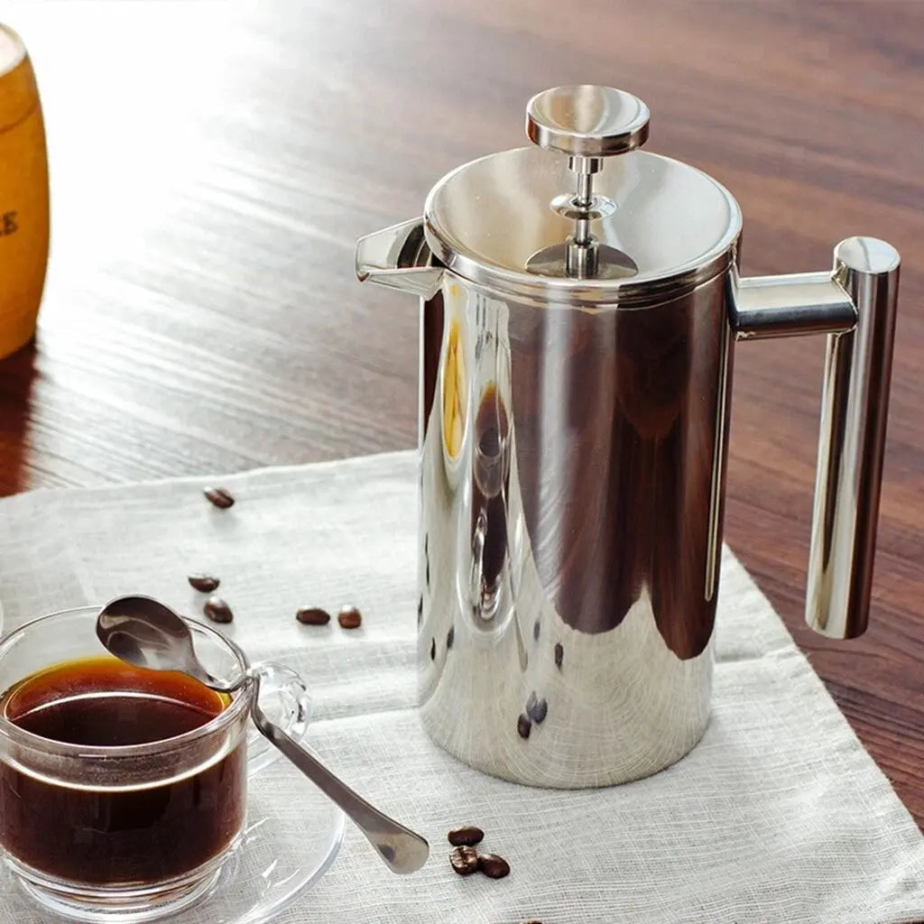 Double wall stainless steel French press with polished finish and coffee beans