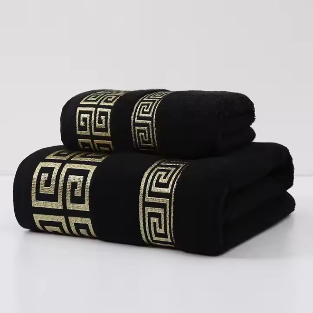 Black bath towel set featuring gold meander fret embroidery and geometric detail