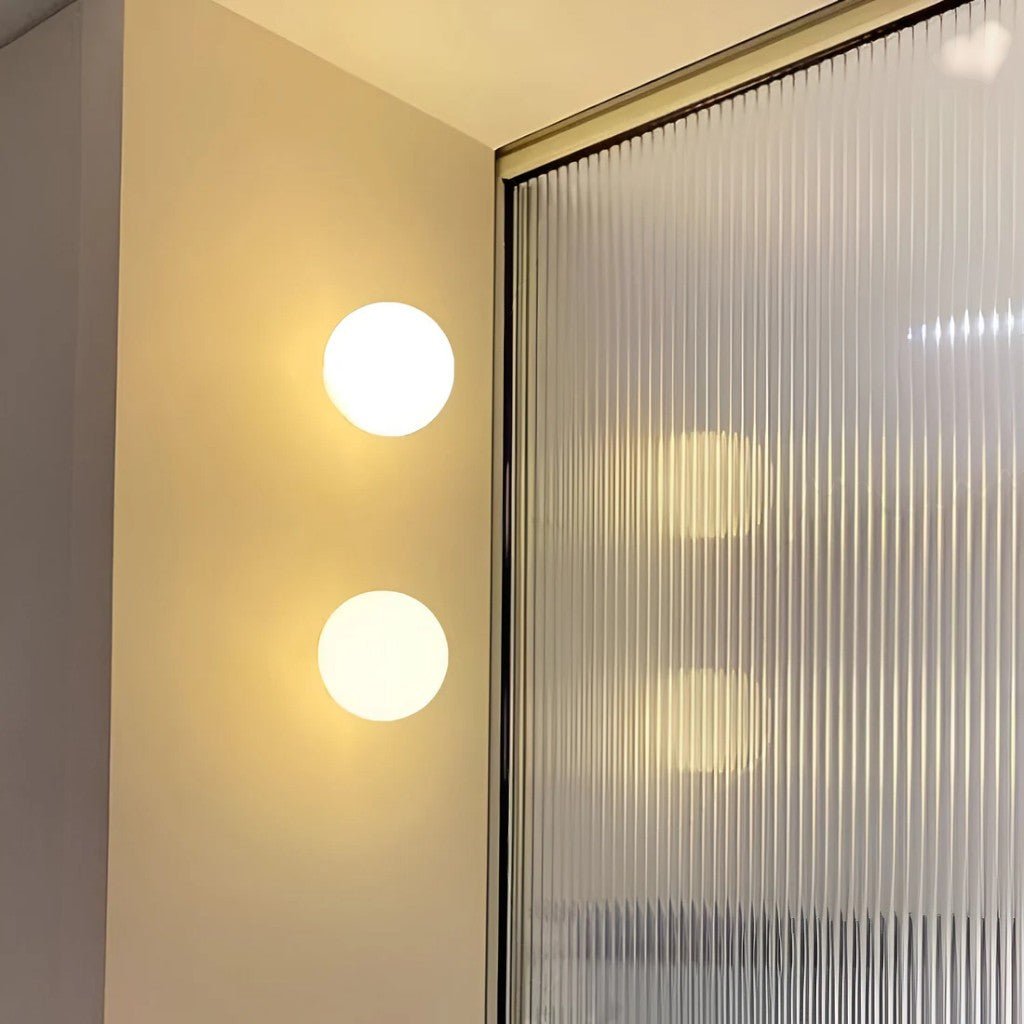Japandi spherical frosted glass wall sconce pair floating on beige wall