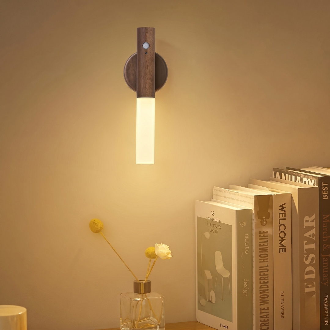 Rechargeable wall lamp with dark wood finish illuminating bedroom reading nook