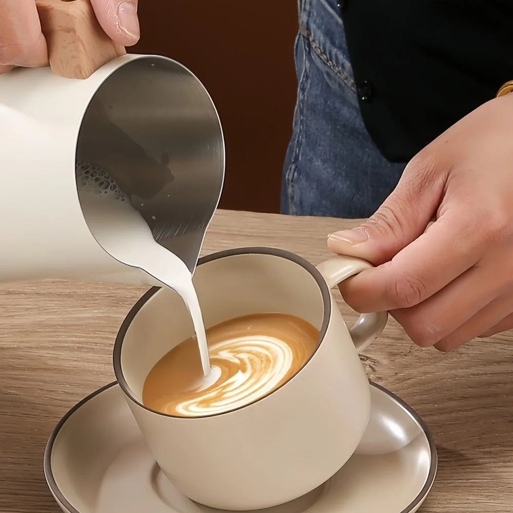 Pouring steamed milk from white matte pitcher to create spiral latte art in espresso cup