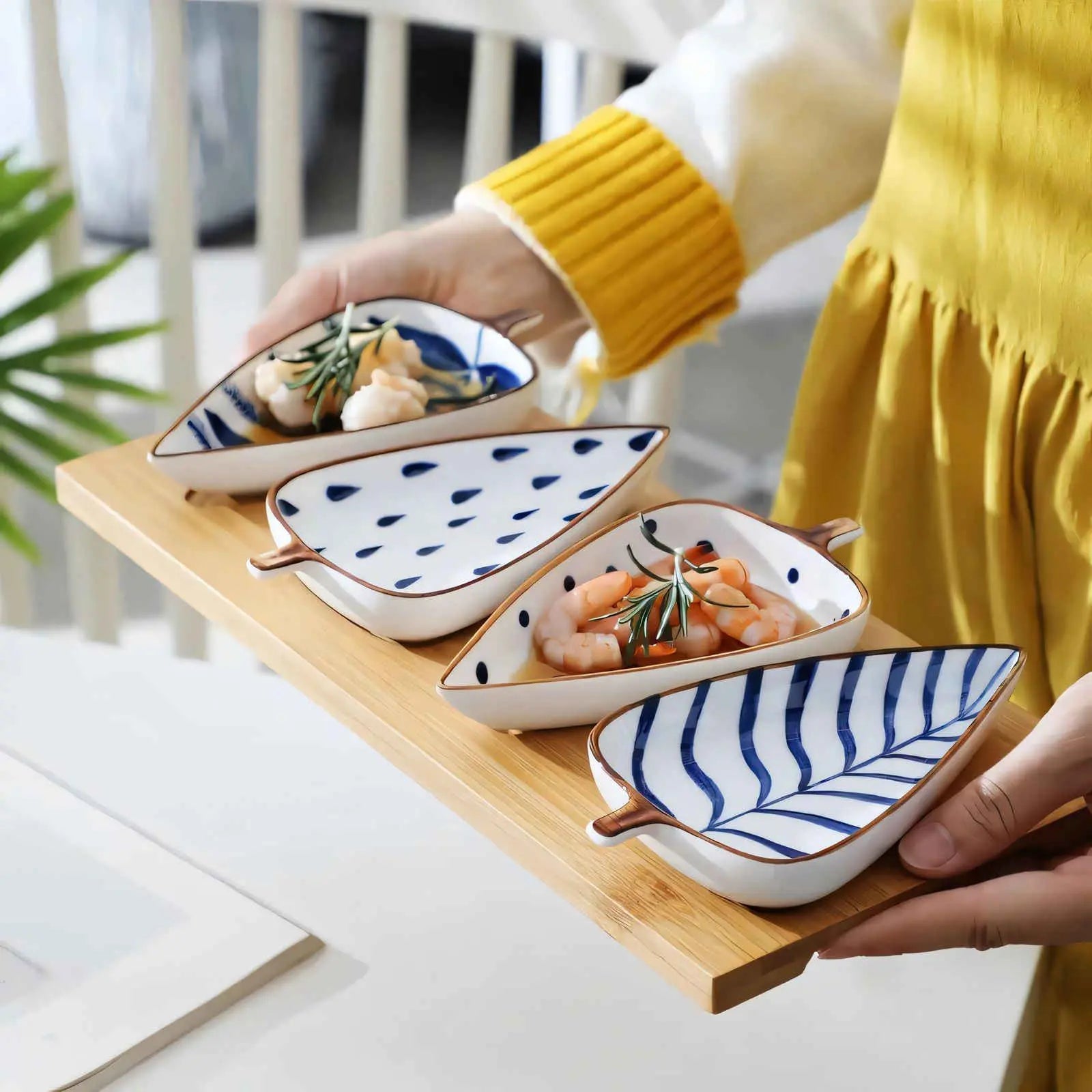 Nordic ceramic leaf serving dishes on bamboo tray with blue patterns and rosemary shrimp