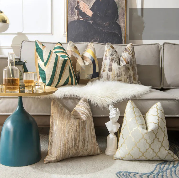 Lifestyle shot of assorted abstract metallic accent pillows on gray sofa