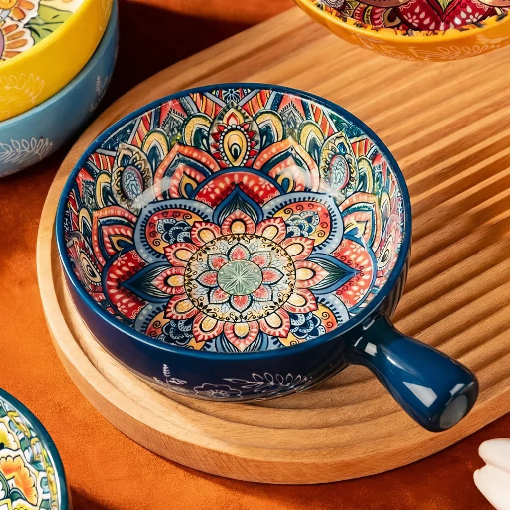 Close-up of dark blue ceramic bowl with handle featuring vibrant multi-layered mandala artwork