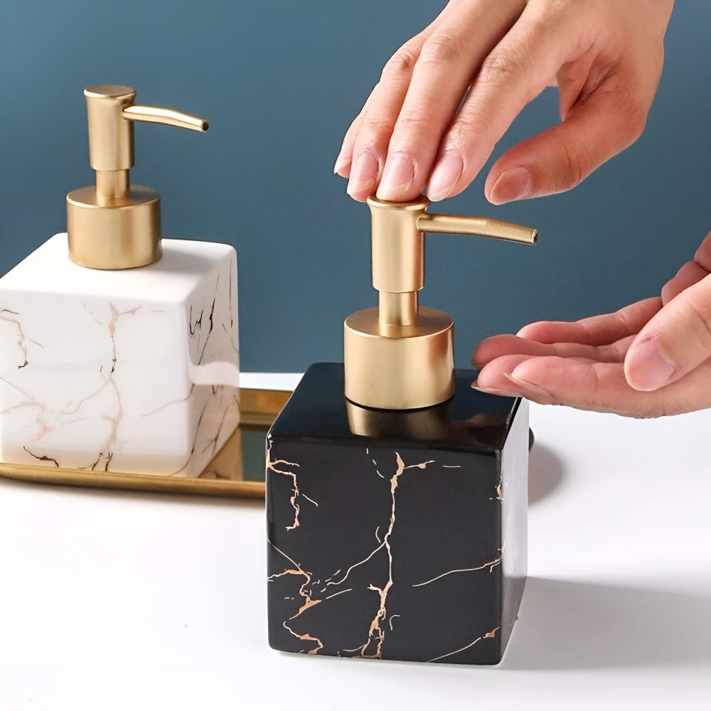 Black marble ceramic soap dispenser with gold pump in use