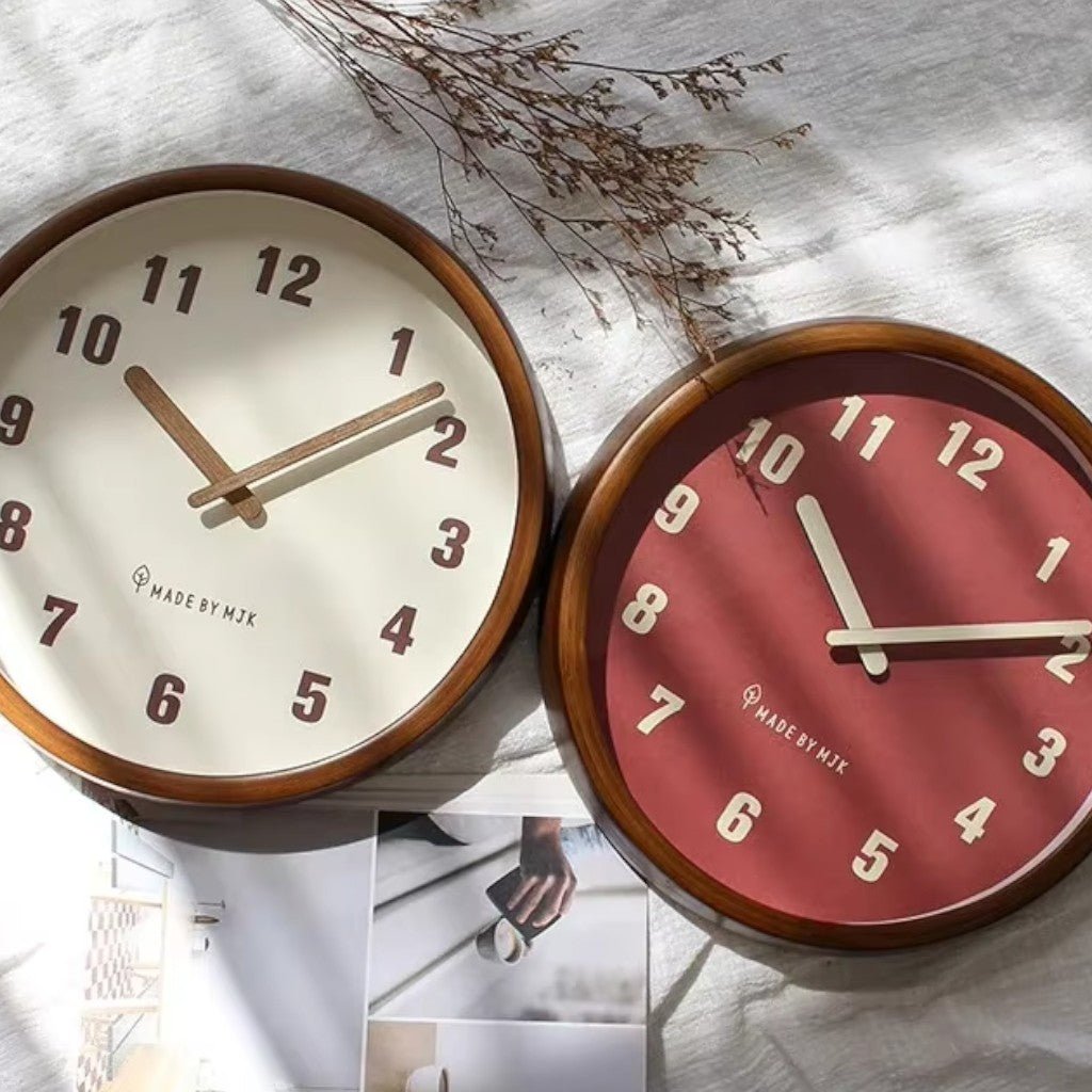 Cream and red round wooden wall clocks side by side with dried plants
