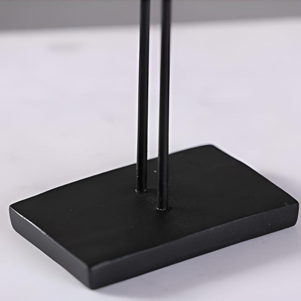 Close-up of matte black rectangular base with vertical rods for bird figurine
