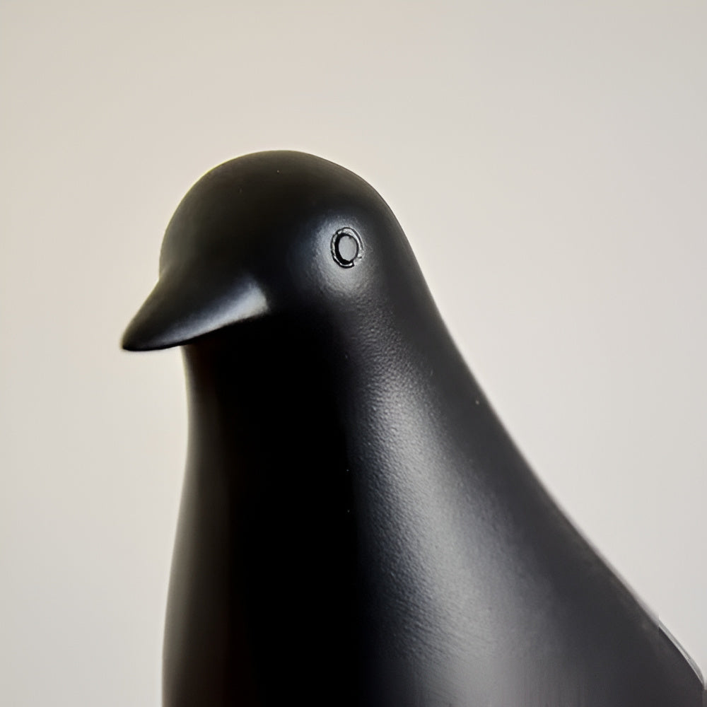 Side profile of matte black ceramic look bird statue with smooth silhouette