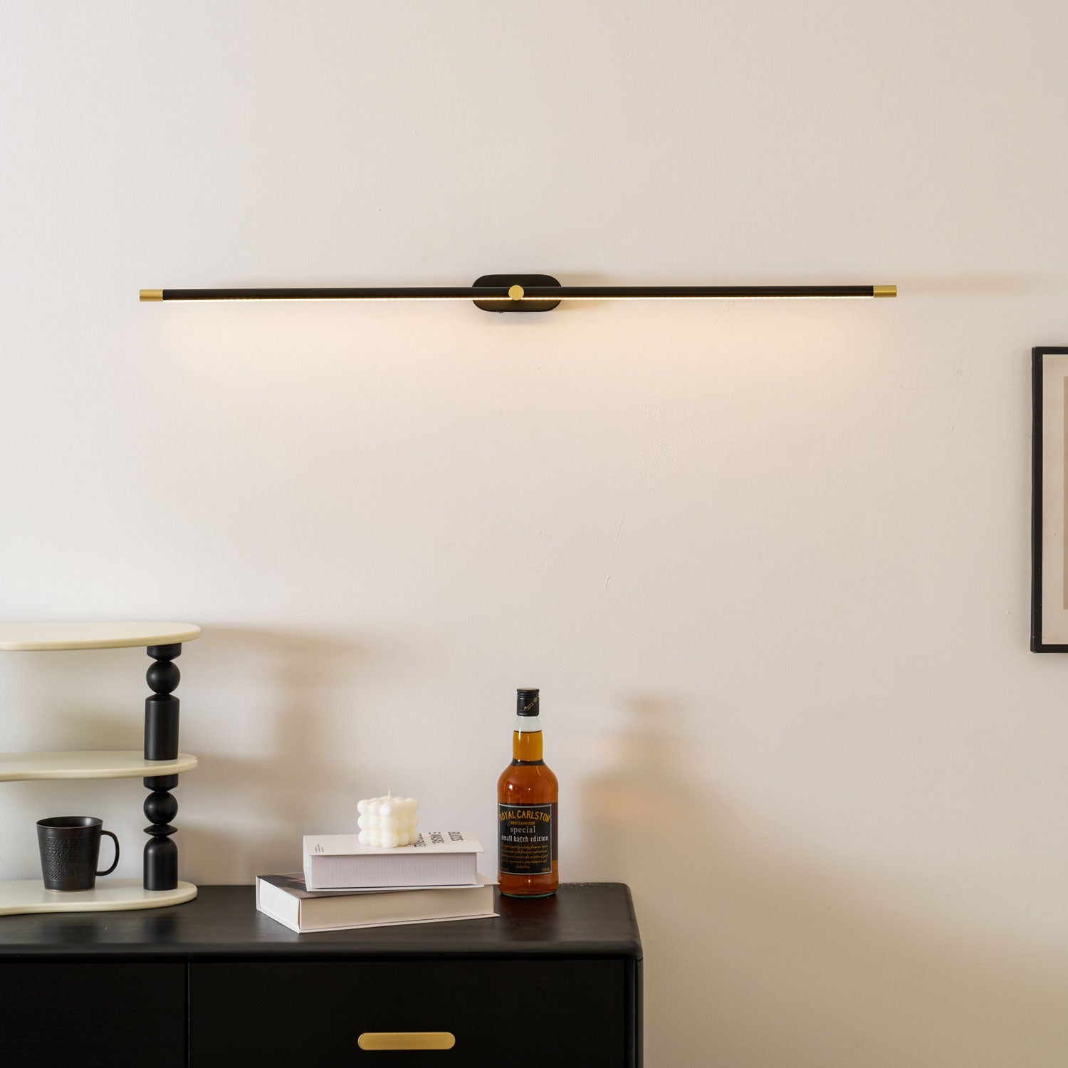 Dimmable LED strip wall light casting warm glow over dark wood dresser