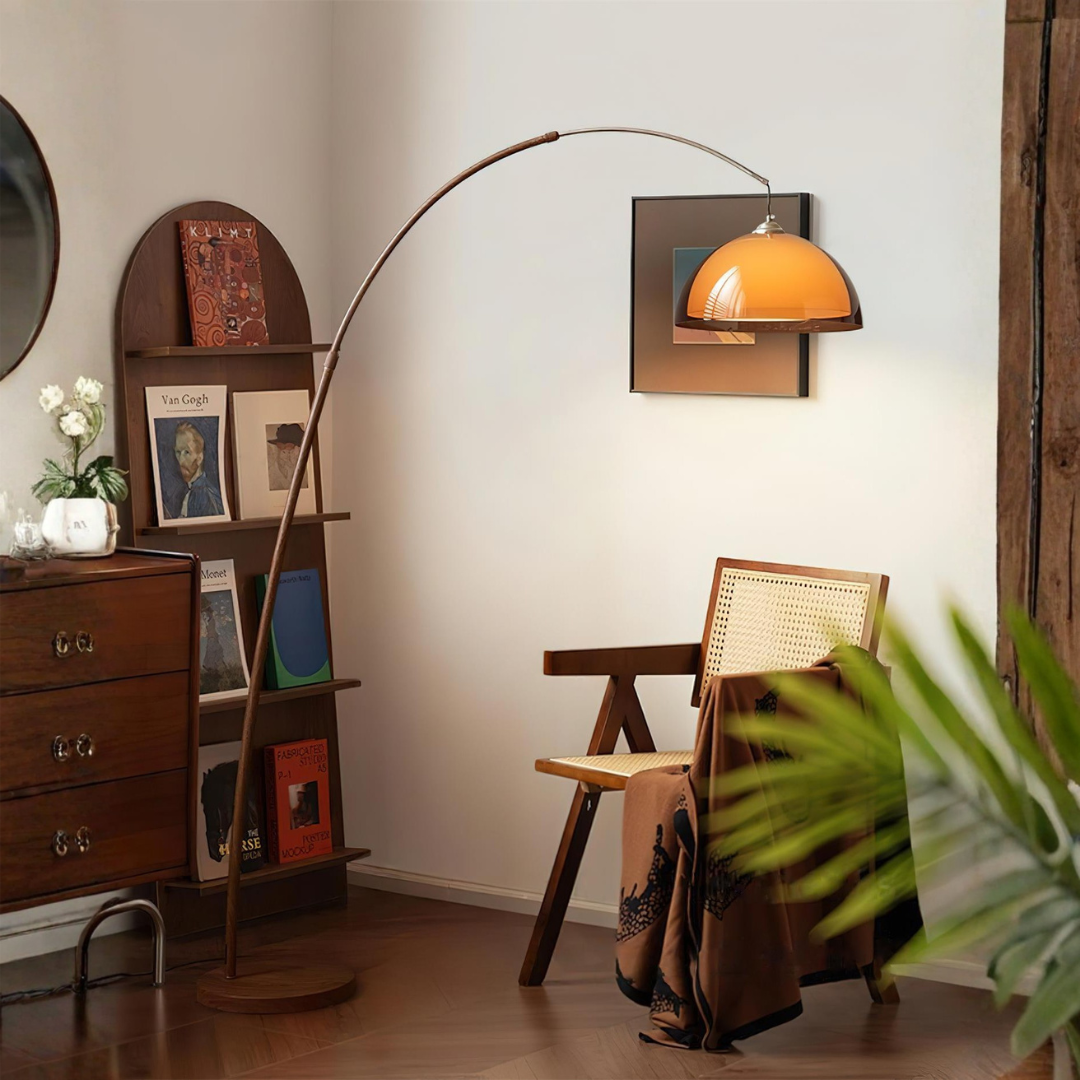 Mid-century modern arc lamp with wooden base near bookshelf and cane chair