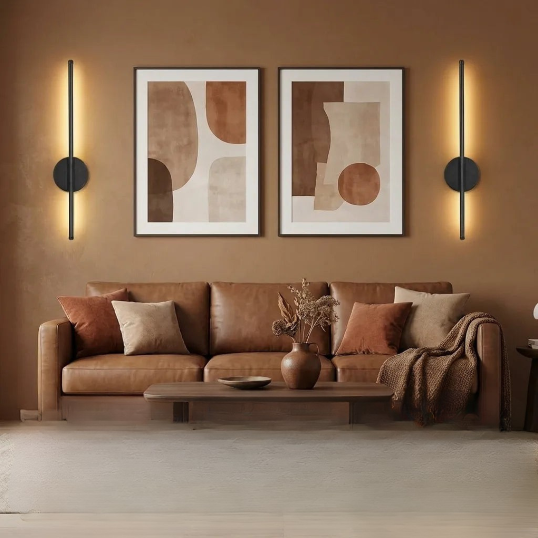 Pair of black vertical wall sconces above leather sofa