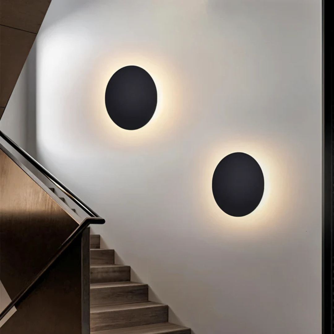 Pair of black aluminum wall sconces illuminating staircase steps