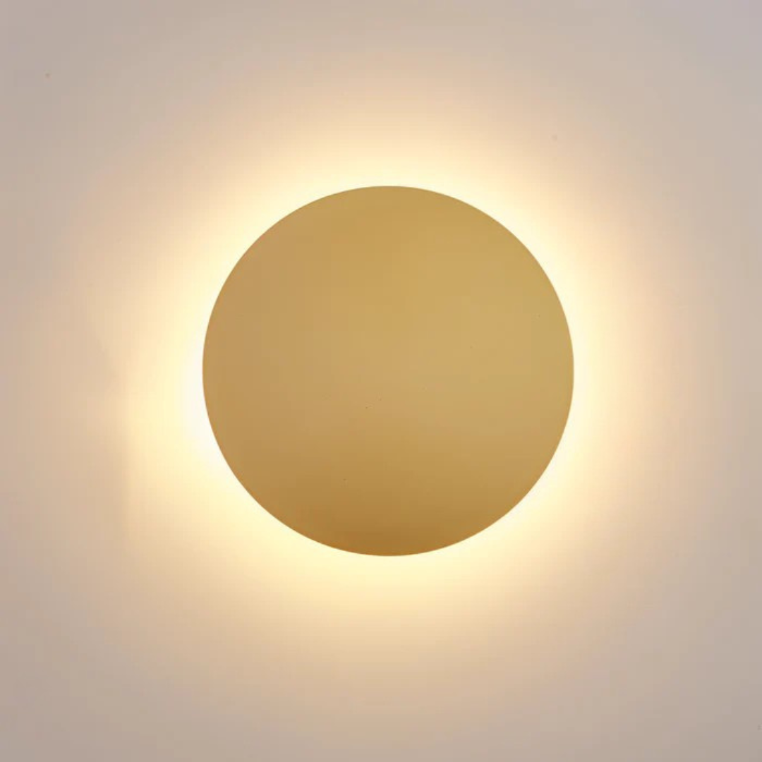 Close-up of black layered disc LED wall sconce with warm white halo glow