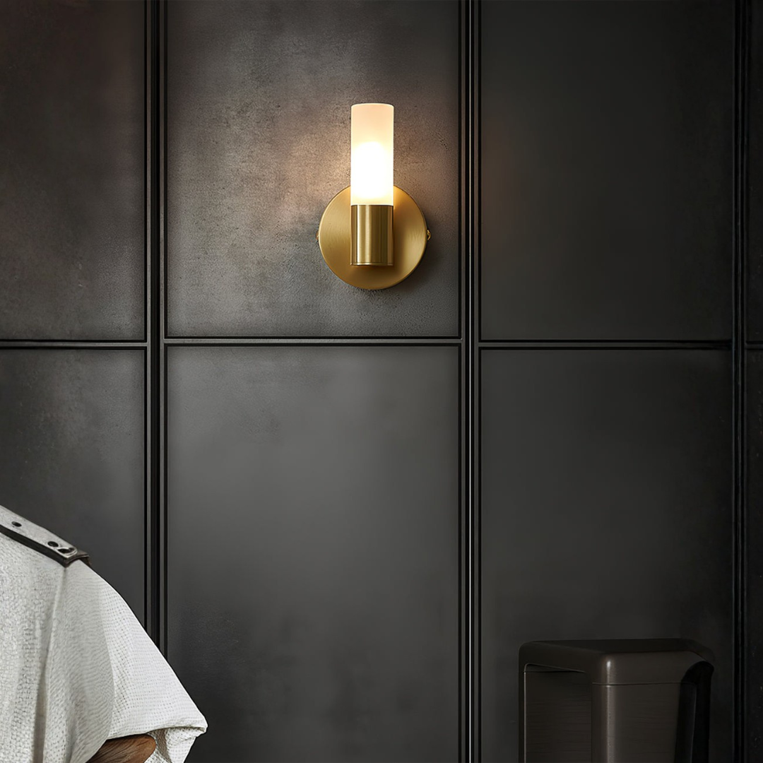 Contemporary brushed brass vanity sconce on paneled gray wall