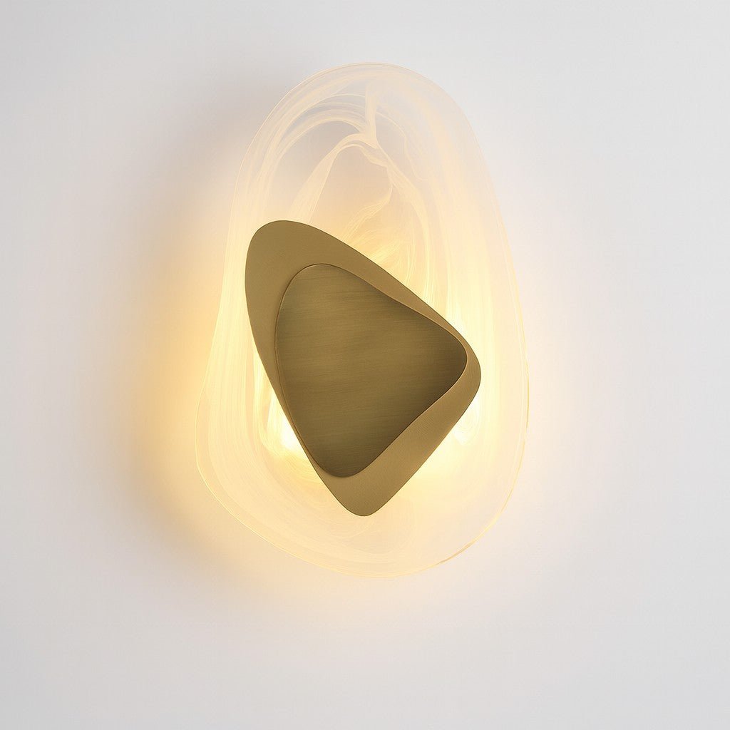 Close-up of brushed gold nested triangles inside textured glass wall sconce