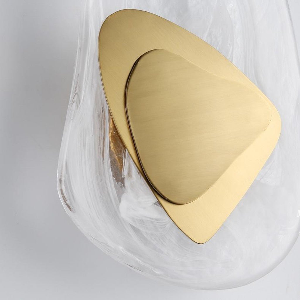 Extreme close-up of matte gold triangular layers inside frosted glass sconce