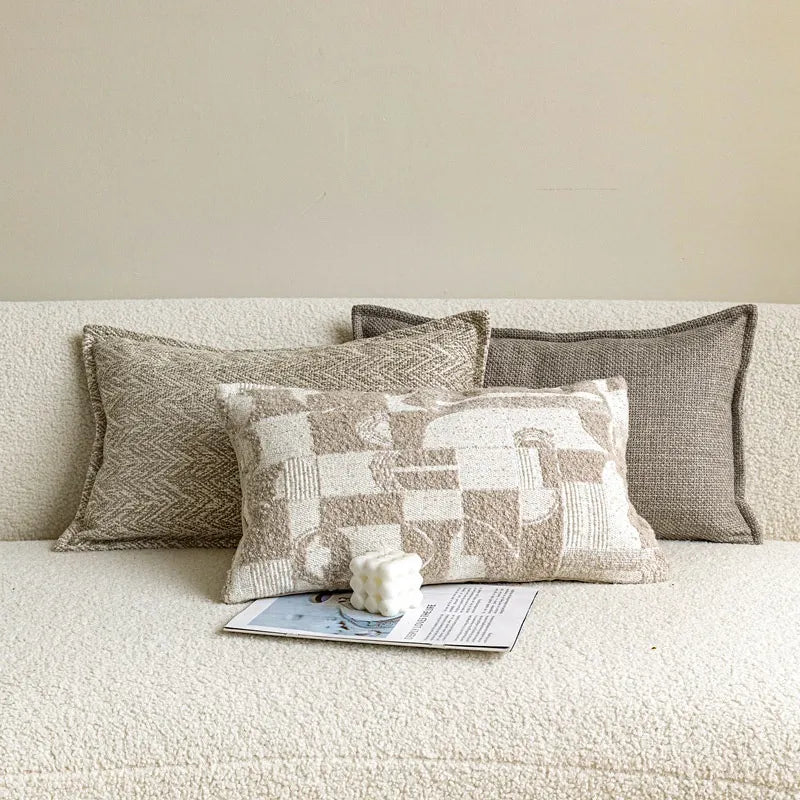 Beige patchwork lumbar pillow with magazine and candle styling