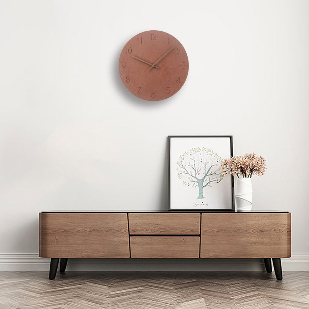 Terracotta minimalist wall clock with copper hands on white wall
