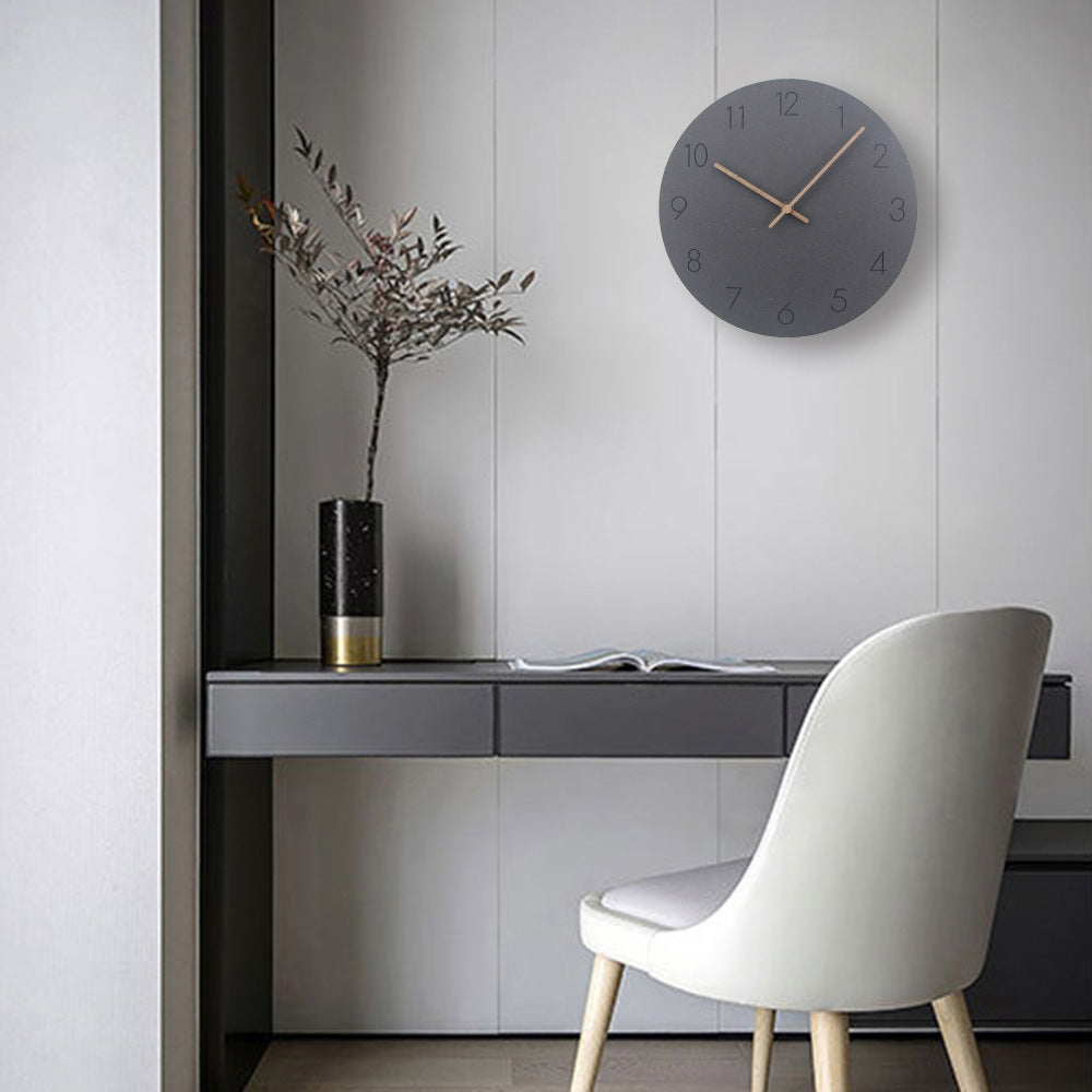 Muted grey wall clock mounted above modern floating desk