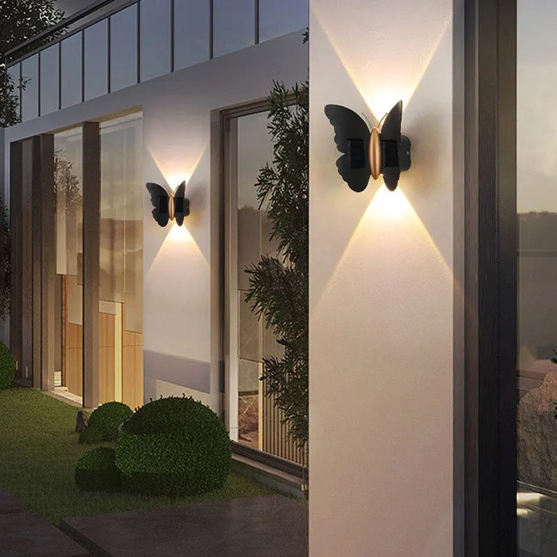 Pair of decorative animal silhouette solar wall lights illuminating a modern patio