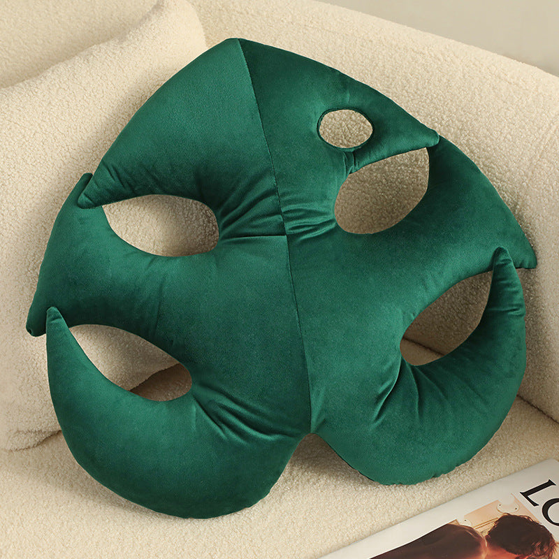 Solid green velvety monstera cushion featuring natural fenestrations