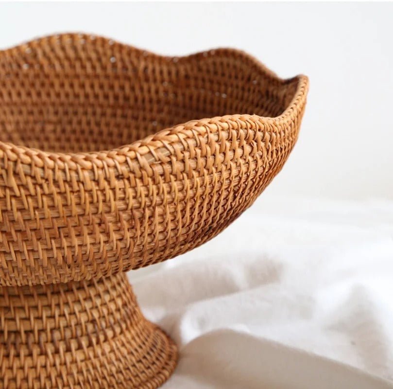 Close-up of wavy scalloped rim on handwoven natural rattan pedestal basket