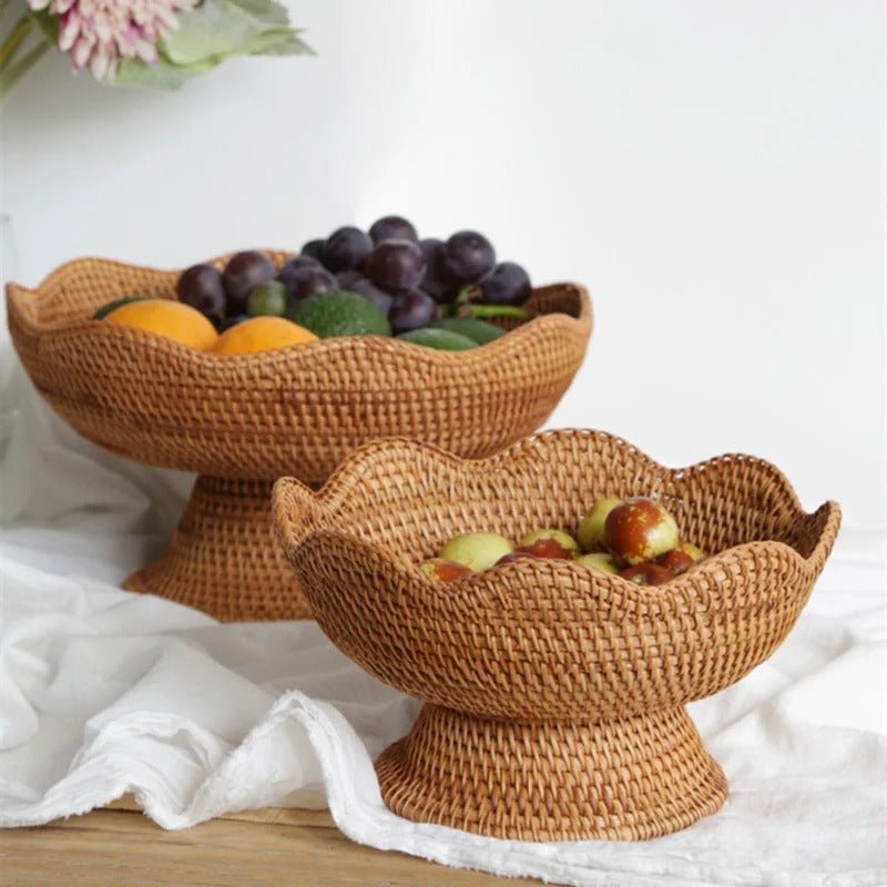 Natural rattan fruit basket with pedestal stand holding fresh apples and grapes