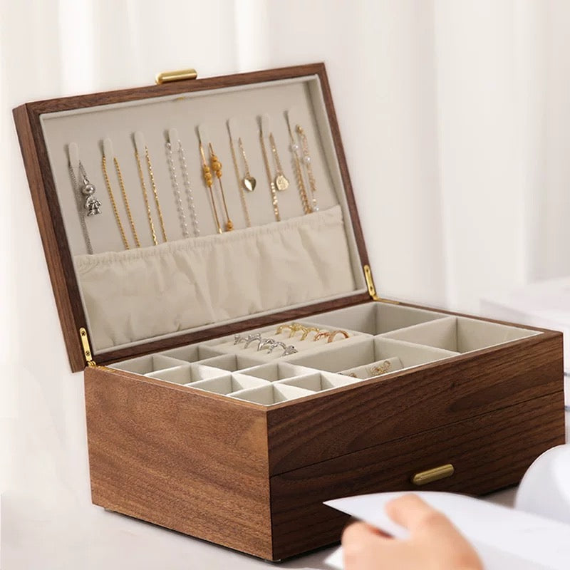 Front view of open walnut jewelry box with hanging hooks for chains and grid compartments for rings