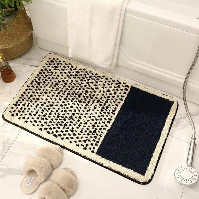 Navy blue and cream abstract dot pattern plush bath mat on white marble