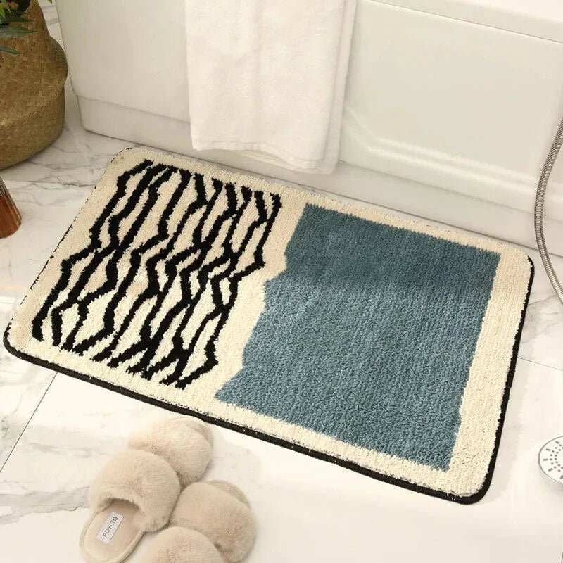 Teal blue and cream abstract wavy line plush bath mat beside bathtub